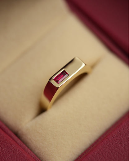 A gold ring with a red baguette ruby gemstone, crafted in solid Australian gold.